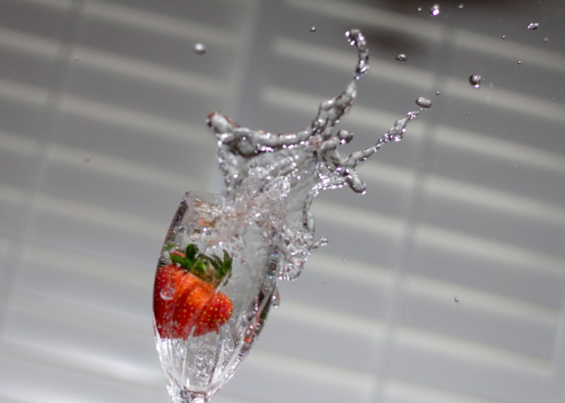 Red Strawberry Drops into Goblet