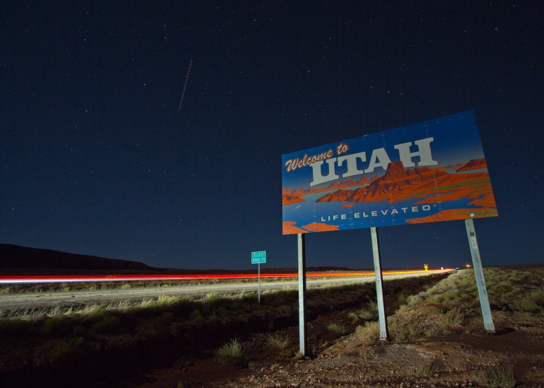 Welcome to Utah sign photo road passing car